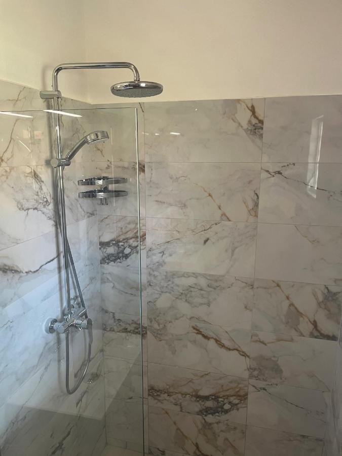 Glazen douchewand en marmeren tegels
