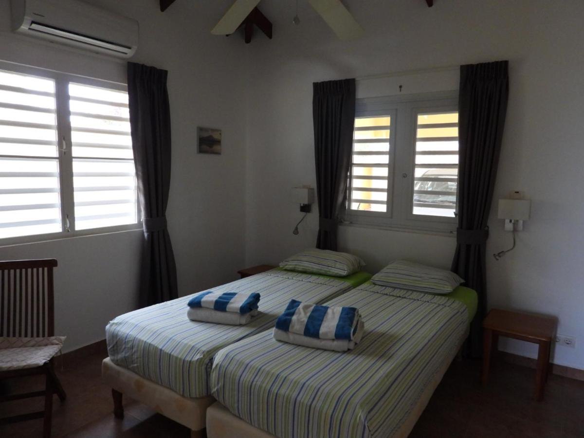 Slaapkamer met twee bedden en plafondventilator