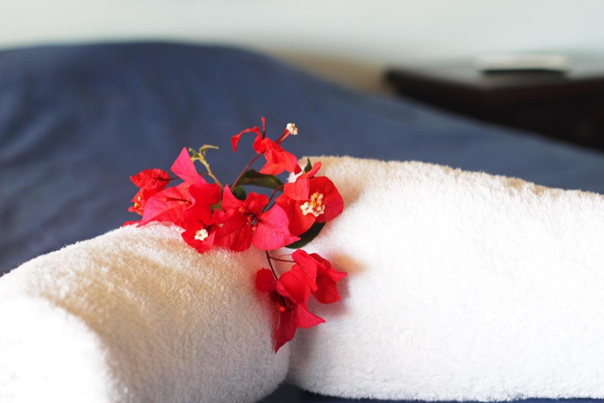 Opgevouwen handdoek met een bougainvillea-bloem